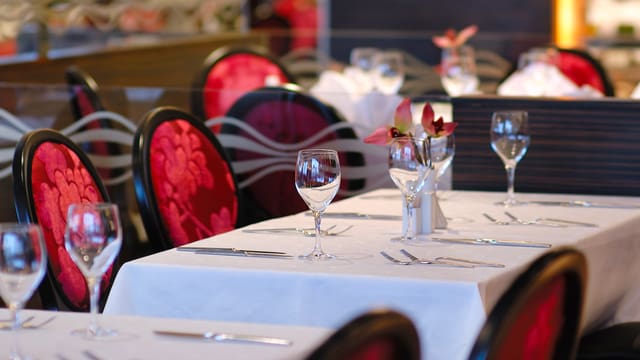 Blick in ein Restaurant, wo ein gedeckter Tisch für Gäste bereit steht. Blick in ein Restaurant, wo ein gedeckter Tisch für Gäste bereit steht.