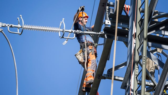 Mann arbeitet an einem Strommast. Mann arbeitet an einem Strommast.