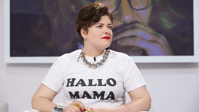 Eine Frau trägt ein weisses Shirt mit dem Schriftzug «Hallo Mama». Eine Frau trägt ein weisses Shirt mit dem Schriftzug «Hallo Mama».