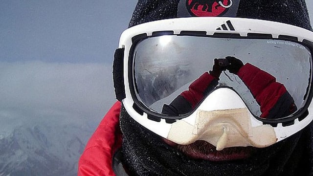 Ein Selfie mit einer Skibrille. Im Visier spiegelt sich die umliegende Bergwelt und die Sonne. Ein Selfie mit einer Skibrille. Im Visier spiegelt sich die umliegende Bergwelt und die Sonne.