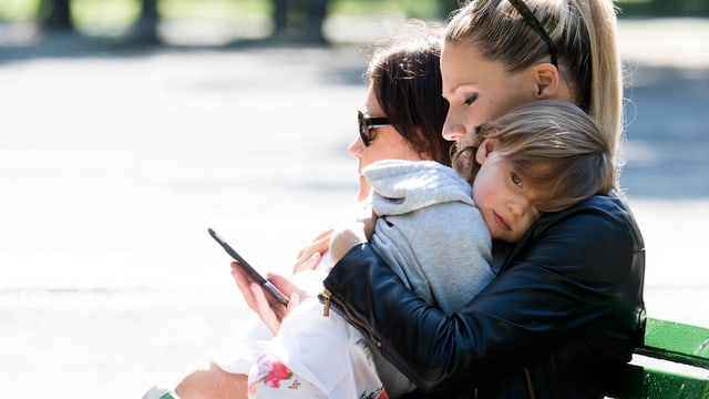 Michelle Hunziker sitzt auf einer Parkbank und hält ein Mädchen auf dem Arm. Michelle Hunziker sitzt auf einer Parkbank und hält ein Mädchen auf dem Arm.