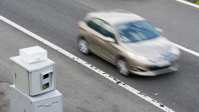 Auto fährt an einem Blitzkasten vorbei. Auto fährt an einem Blitzkasten vorbei.