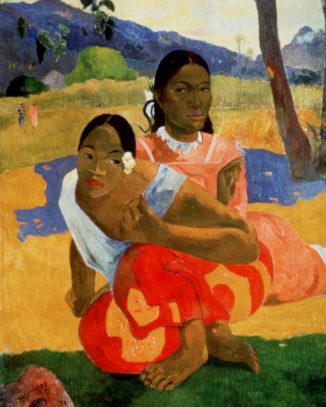 Zwei dunkelhäutige Frauen mit zusammengebundenen schwarzen Haaren, in farbigen Gewändern barfuss auf dem Boden sitzend.