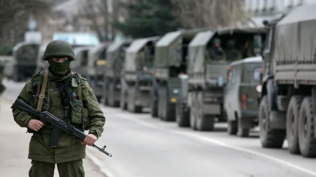 Soldat beobachtet einen Konvio von Militärfahrzeugen. Soldat beobachtet einen Konvio von Militärfahrzeugen.