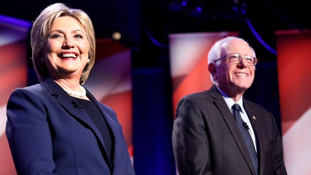Clinton steht neben Sanders im Rampenlicht. Clinton steht neben Sanders im Rampenlicht.
