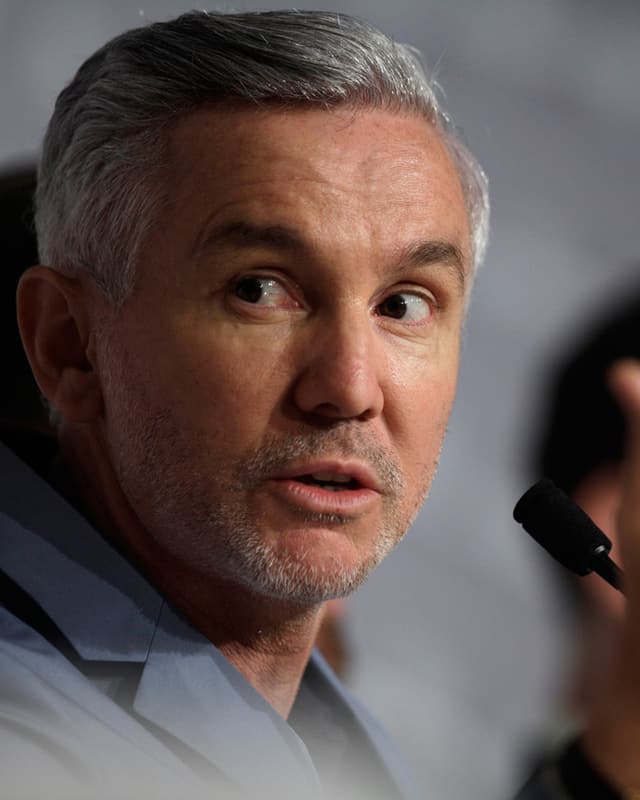Nahaufnahme von Luhrmann, der während einer Pressekonferenz ins Mikrofon spricht. Nahaufnahme von Luhrmann, der während einer Pressekonferenz ins Mikrofon spricht.