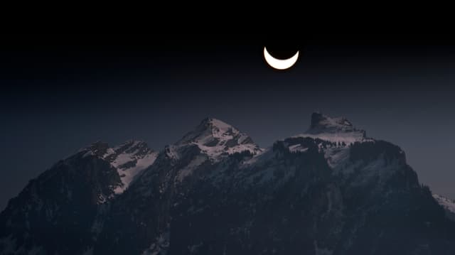 Sonnensichel über den Bergen in Studen