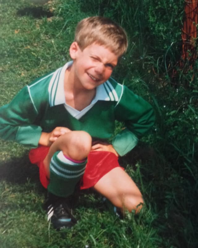 Ein kleiner Junge in grünem Fussballleibchen und roten Hosen. Ein kleiner Junge in grünem Fussballleibchen und roten Hosen.
