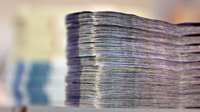 Ein sehr grosses Bündel Banknoten auf einem Tisch. Ein sehr grosses Bündel Banknoten auf einem Tisch.