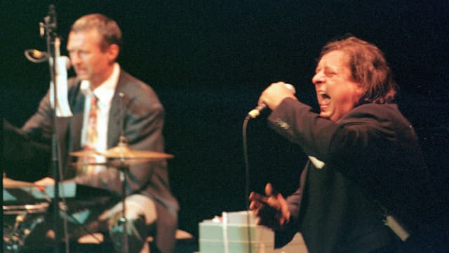 Balts Nill am Schlagzeug und Endo Anaconda 1998 beim Auftritt an der Frankfurter Buchmesse, anlässlich der Schweizer Nacht. Balts Nill am Schlagzeug und Endo Anaconda 1998 beim Auftritt an der Frankfurter Buchmesse, anlässlich der Schweizer Nacht.