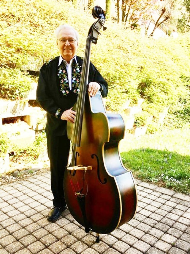 Mann mit Kontrabass steht auf Terrasse. Mann mit Kontrabass steht auf Terrasse.