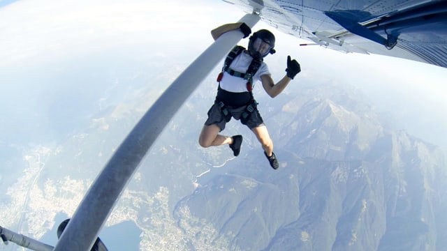 Ein Mann hält sich an einem Flugzeug fest. Ein Mann hält sich an einem Flugzeug fest.