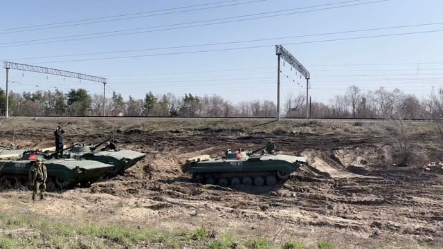 Mehrere russische Panzer stehen hintereinander neben Bahngeleisen Mehrere russische Panzer stehen hintereinander neben Bahngeleisen