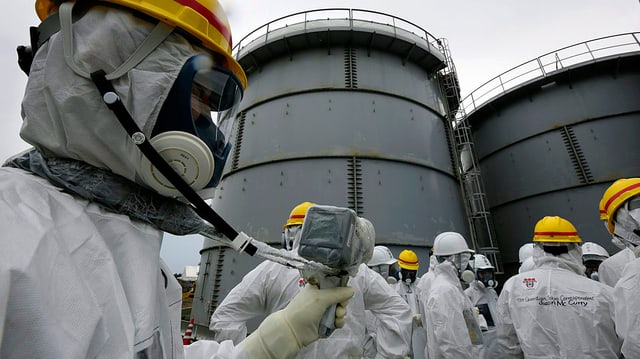 Spezialisten in weissen Schutzanzügen messen die Umgebungs-Radioaktivität im japanischen Kernkraftwerk Dai-ichi in Fukushima. Spezialisten in weissen Schutzanzügen messen die Umgebungs-Radioaktivität im japanischen Kernkraftwerk Dai-ichi in Fukushima.