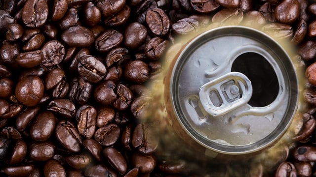 Eine offene Getränkedose inmitten von Kaffeebohnen Eine offene Getränkedose inmitten von Kaffeebohnen