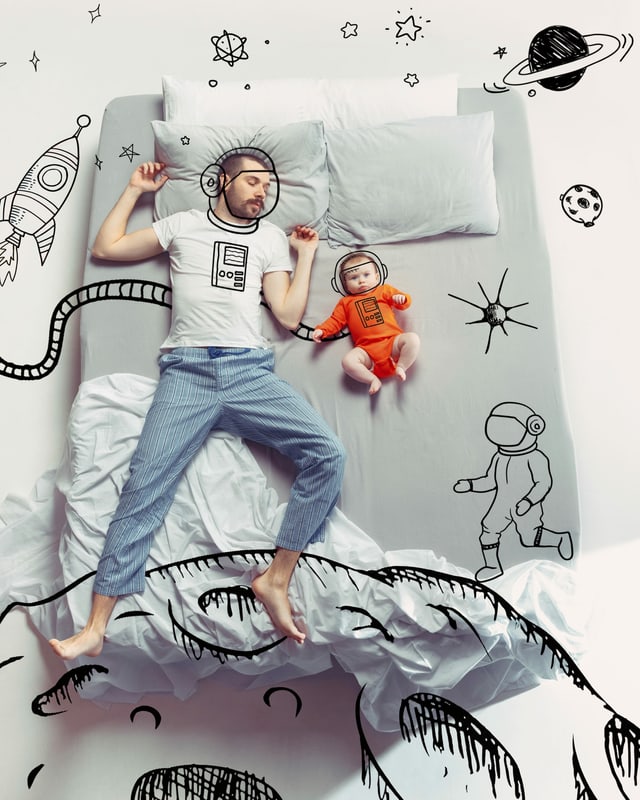 Ein Mann und sein kleines Kind schlafen im Bett. Ein Mann und sein kleines Kind schlafen im Bett.
