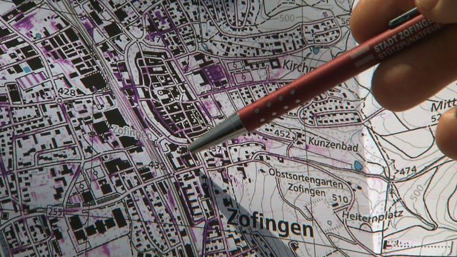 Karte mit lila Stellen, zu sehen ist die Altstadt von Zofingen. Daneben zeigt jemand mit einem Kugelschreiber auf die Karte. Karte mit lila Stellen, zu sehen ist die Altstadt von Zofingen. Daneben zeigt jemand mit einem Kugelschreiber auf die Karte.