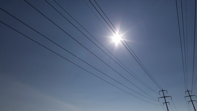 Die Sonne scheint über Stromleitungen Die Sonne scheint über Stromleitungen