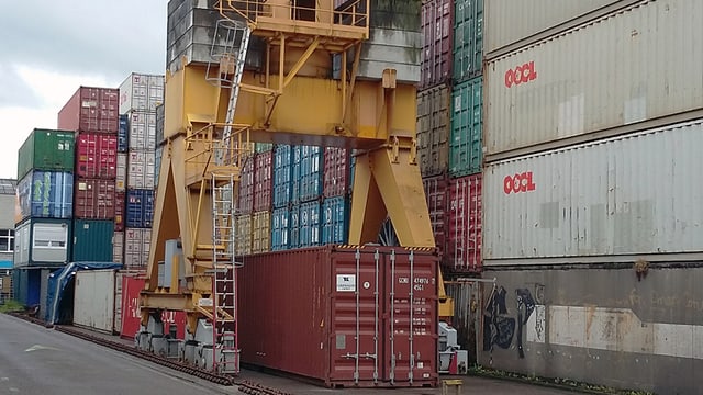 Gestapelte Container und ein Kran im Depot der Leimgruber AG in Basel.