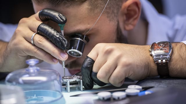 Uhrmacherlehrling montiert eine Uhr Uhrmacherlehrling montiert eine Uhr