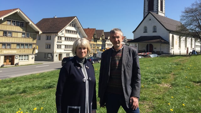 Porträt sie links, er rechts im Hintergrund die Kirche und Häuser Porträt sie links, er rechts im Hintergrund die Kirche und Häuser