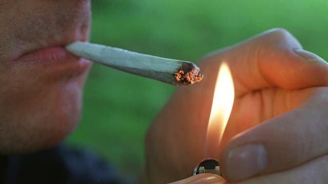 Der Ausschnitt eines Menschen, der sich gerade einen Joint anzündet. Der Ausschnitt eines Menschen, der sich gerade einen Joint anzündet.