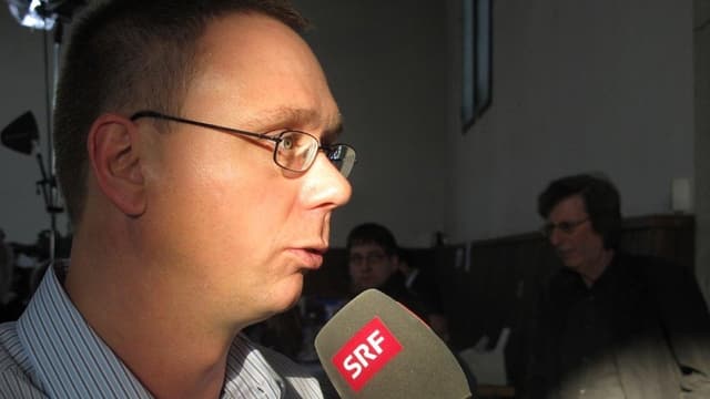 Ein Mann spricht in ein Mikrofon Ein Mann spricht in ein Mikrofon