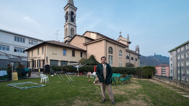 Mann auf einem Rasenplatz vor einer Kirche. Mann auf einem Rasenplatz vor einer Kirche.