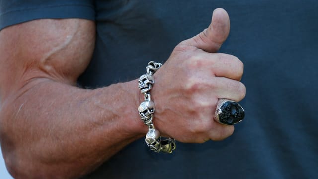 Ein Arm mit einer Totenkopf-Kette ums Handgelenk.