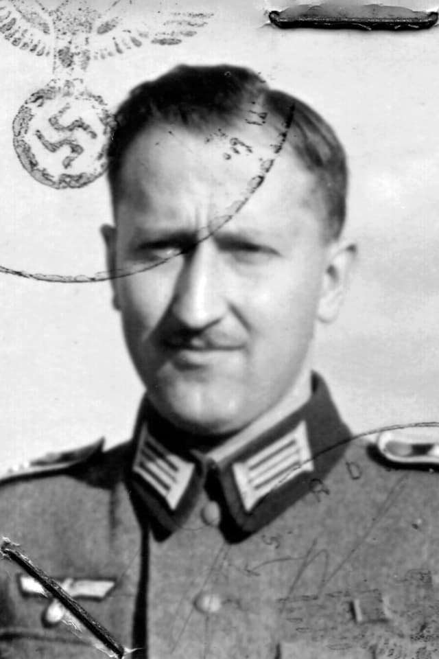 Ein Foto eine Mannes. Es trägt einen Stempfel mit einem Hakenkreuz. Ein Foto eine Mannes. Es trägt einen Stempfel mit einem Hakenkreuz.