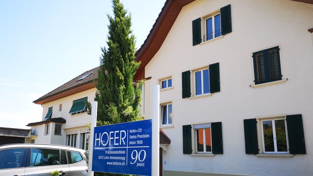 Gebäude mit Firmen-Schild im Vordergrund. Gebäude mit Firmen-Schild im Vordergrund.