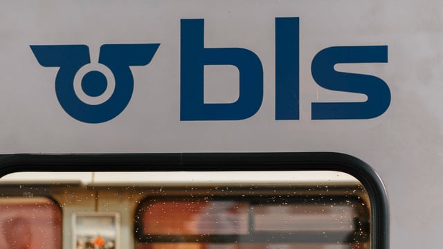 Das Logo der BLS über einem Zug-Fenster. Das Logo der BLS über einem Zug-Fenster.