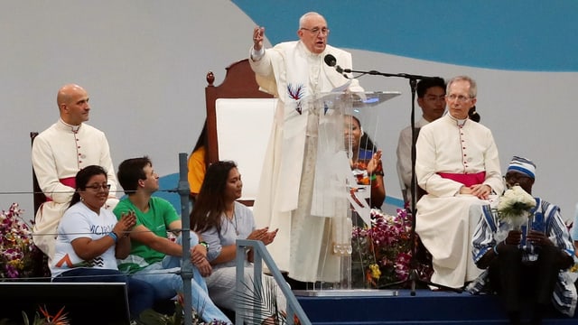 Papst Franziskus auf einem Podium vor einem Rednerpult. Papst Franziskus auf einem Podium vor einem Rednerpult.