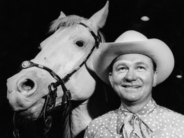 Tex Ritter mit Cowboy-Hut neben einem Pferd Tex Ritter mit Cowboy-Hut neben einem Pferd