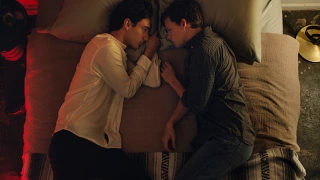 Zwei junge Männer liegen sich gegenüber auf einem Bett