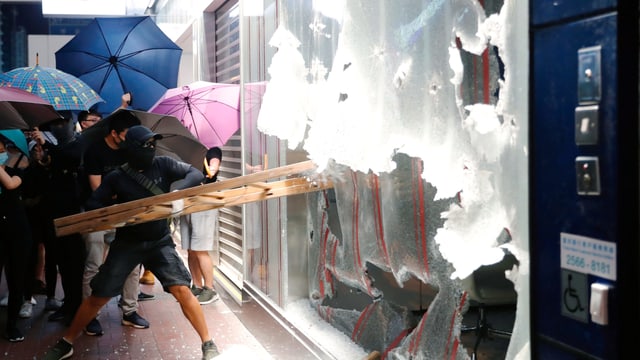 Demonstrant schlägt Schaufenster ein Demonstrant schlägt Schaufenster ein
