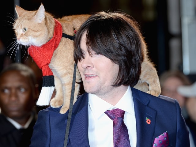 James Bowen und Katze Bob. DIe Katze sitzt auf seienr Schulter James Bowen und Katze Bob. DIe Katze sitzt auf seienr Schulter