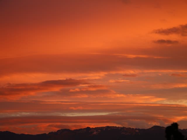 Die Wolken werden rot angeschienen, es scheint, als ob der Himmel brenne.