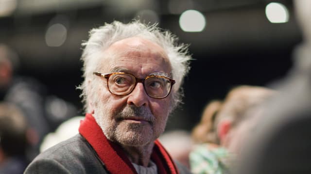 Älterer Mann mit Bart, Brille und roten Schal