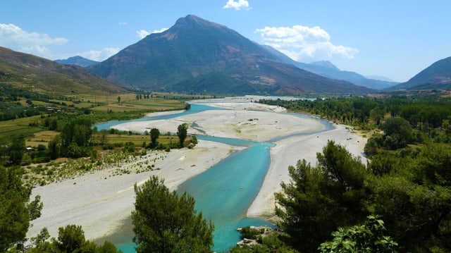 Der Fluss Vjosa bei Tepelene, im Hintergrund ein mächtiger Kegelberg.