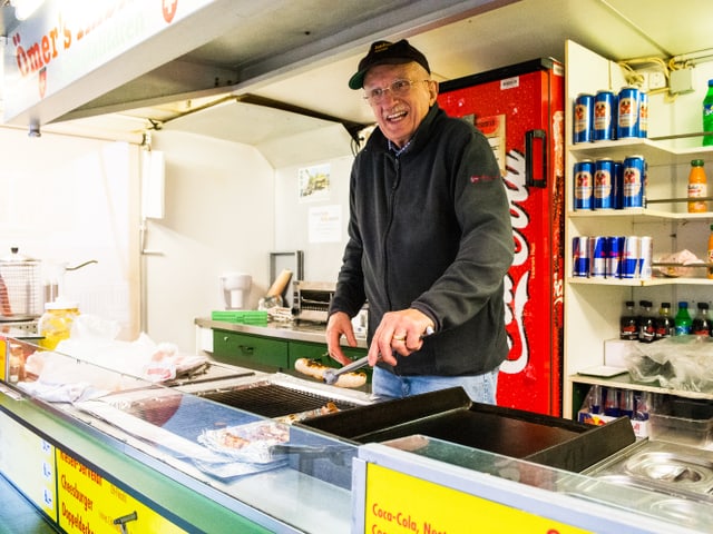 Ömer greift eine Bratwurst mit der Zange. Ömer greift eine Bratwurst mit der Zange.