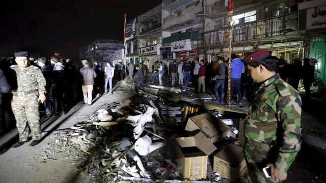 Uniformierte sichern die Strasse nach der Explosion einer Autobombe. Uniformierte sichern die Strasse nach der Explosion einer Autobombe.