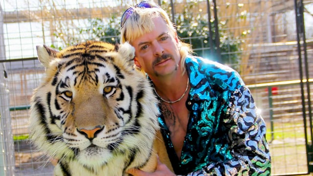 Mann mit Tiger im Arm.