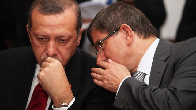 Davutoglu flüstert Erdogan etwas ins Ohr. Davutoglu flüstert Erdogan etwas ins Ohr.