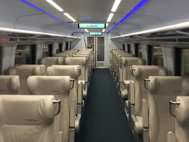 Ein leerer Zugwaggon, ohne Passagiere. Die crémefarbenen Sitze aus Kunstleder sehen neu aus. An der Decke glimmen nebst dem normalen Licht blaue Neonröhren. Ein leerer Zugwaggon, ohne Passagiere. Die crémefarbenen Sitze aus Kunstleder sehen neu aus. An der Decke glimmen nebst dem normalen Licht blaue Neonröhren.