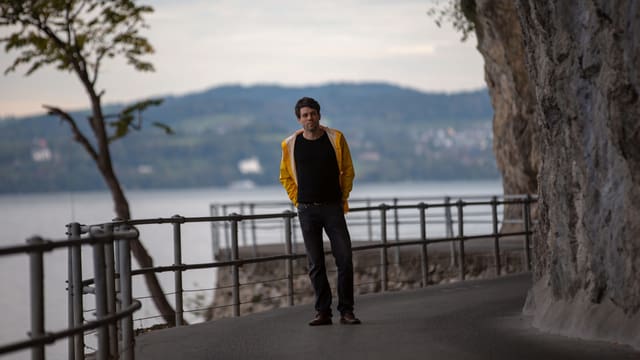 Ein Mann steht am Seeufer Ein Mann steht am Seeufer