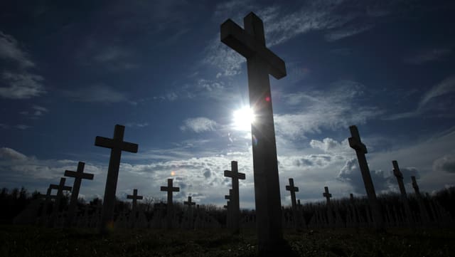 Kreuze zur Erinnerung an Kriegsopfer stehen auf einem Feld. Kreuze zur Erinnerung an Kriegsopfer stehen auf einem Feld.