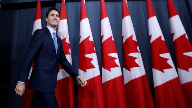 Der kanadische Premierminister Trudeau, hinter ihm viele kanadische Fahnen. Der kanadische Premierminister Trudeau, hinter ihm viele kanadische Fahnen.