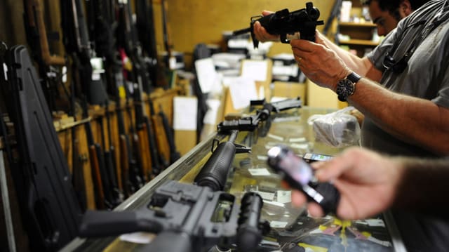 Männer in Waffengeschäft stehend, Waffen begutachtend Männer in Waffengeschäft stehend, Waffen begutachtend