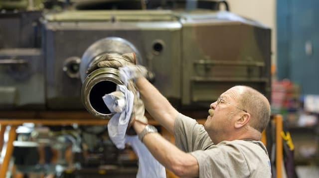 Mitarbeiter reinigt Panzer Mitarbeiter reinigt Panzer
